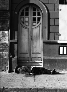 Homeless man laying by a door